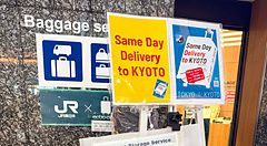 Cartelli informativi relativi al servizio di deposito e consegna bagagli situati nella stazione di Tokyo.