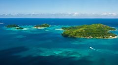 Vista aerea delle isole Seychelles tra acque turchesi e verde vegetazione.