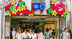 L'ingresso dello Shibuya 109 a Shibuya con diverse persone, tra cui studentesse in divisa, che escono dal centro commerciale.