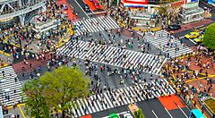 Shibuya Crossing a Tokyo, affollato di persone che attraversano l'incrocio.