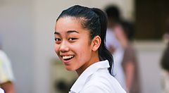 Giovane donna sorridente con camicia bianca a Shibuya.