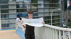 Una persona su un ponte pedonale a Shinjuku con una mappa.