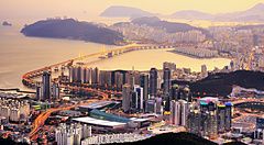 Skyline di Busan, Corea del Sud al crepuscolo con ponti e edifici moderni.