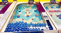 Macchine da gioco vintage in stile flipper con biglie blu presso la sala giochi Smartball New Star a Osaka.