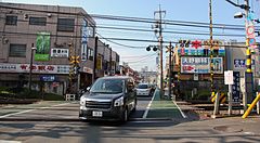 Auto che attraversano un passaggio a livello con edifici circostanti