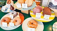 Donut vegani esposti su piatti colorati nel negozio Sunday Vegan a Kichijoji.