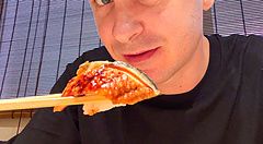 Marco Togni tiene in mano un pezzo di sushi con le bacchette all'interno del Ristorante New Sushi Center Harukiya a Osaka.