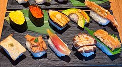 Assortimento di nigiri vegani serviti su piatti di ardesia nera presso il ristorante Vegan Sushi Tokyo a Shibuya.