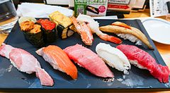 Assortimento di sushi su un vassoio nero al ristorante Sushi Zanmai.