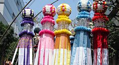 Decorazioni colorate del Tanabata festival a Sendai, Giappone, con persone che passeggiano sotto.