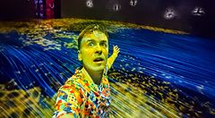 Marco Togni in una sala immersiva a teamLab Borderless Tokyo con luci colorate.