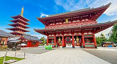 La porta Hozomon e la pagoda del tempio Senso-ji nel quartiere di Asakusa, sotto un cielo azzurro luminoso.