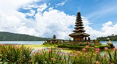 Il tempio Ulun Danu Bratan a Bali su un lago circondato da fiori e montagne.