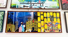 Una parete di un negozio Eirakuya a Kyoto con tenugui incorniciati che mostrano illustrazioni tradizionali giapponesi.