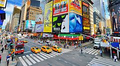 Scena vivace di Times Square a New York con traffico e cartelloni pubblicitari.