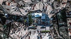 Veduta caleidoscopica attraverso gli specchi dell'ingresso del Tokyu Plaza ad Harajuku, con persone che camminano in strada.
