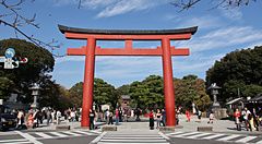 Torii rosso al Santuario Tsurugaoka Hachiman a Kamakura con persone intorno.