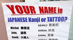 Cartello con nomi tradotti in giapponese per kanji e tatuaggi.