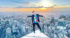 Marco Togni in posa sulla piattaforma panoramica di Shibuya Sky a Tokyo con la città sullo sfondo al tramonto.