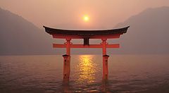 Torii rosso nel santuario di Miyajima al tramonto, Giappone.