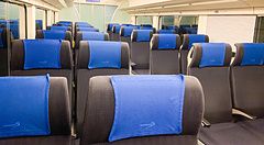 Interno del treno Skyliner con sedili neri e poggiatesta blu.