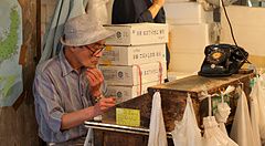 Due uomini lavorano all'interno di una bottega nel vecchio mercato del pesce di Tsukiji a Tokyo.