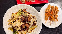 Verdure saltate con carne di soia, spiedini di carne di soia e gyoza su un tavolo al ristorante Sairaien di Ueno.