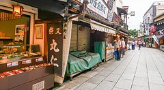 Via commerciale tradizionale a Shibamata con negozi e persone.