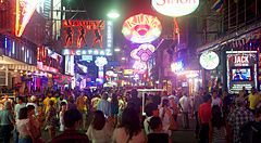 Walking Street a Pattaya affollata di notte con insegne al neon e persone.