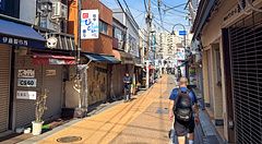 strada di Yanaka Ginza a Tokyo con persone e negozi