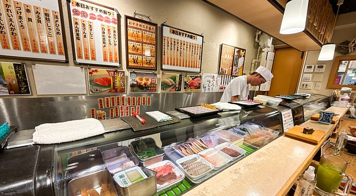Chef al lavoro dietro il bancone del ristorante Maguro Bito.