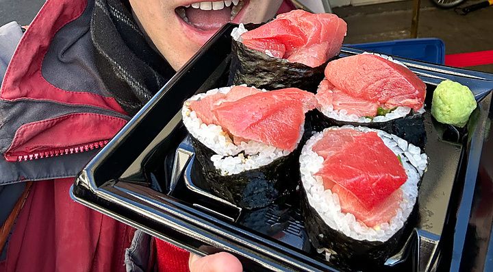 Marco Togni tiene in mano una confezione di maki con tonno acquistata presso la bancarella Maguro Koya a Tsukiji.