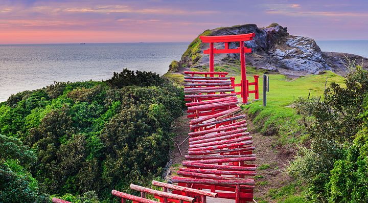 Torii rossi al Motonosumi Inari Shrine in Giappone con vista sull'oceano.