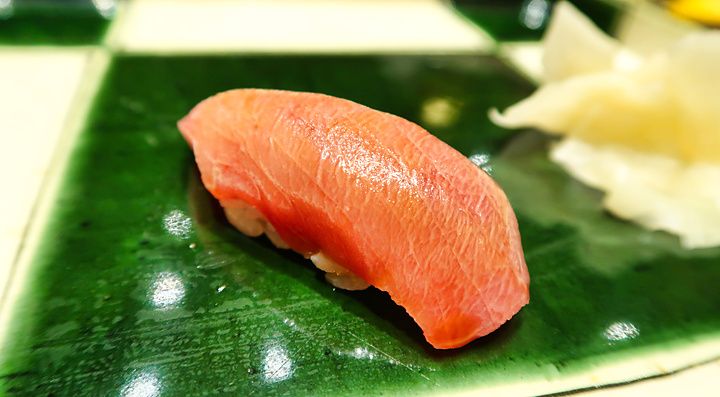 Un nigiri di chutoro servito su un piatto di ceramica verde presso il ristorante Ginza Kyubey di Tokyo.