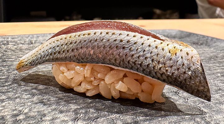 Un nigiri di kohada adagiato su un piatto in pietra presso il ristorante Sushi Punch a Tokyo.
