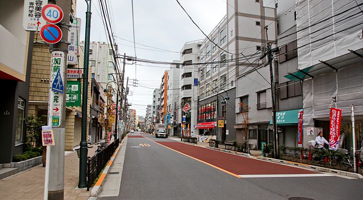 Una strada nel quartiere di Nippori Fabric Town, a Tokyo, fiancheggiata da negozi di tessuti e cavi elettrici aerei.