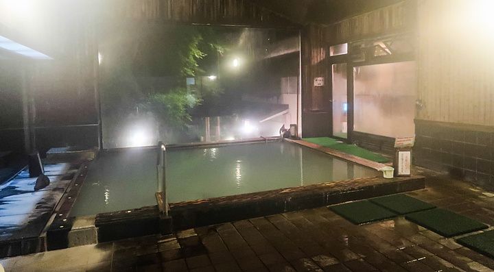 L'onsen a Oku Nikko Hotel Shikisai presenta una vasca termale in legno circondata da ampie vetrate verso l'esterno.