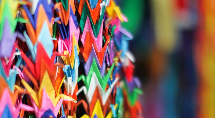 Molteplici gru di carta piegata di diversi colori sono appese in file verticali all'interno del Memoriale di Hiroshima.