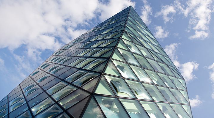 Facciata in vetro dell'edificio Prada Aoyama a Tokyo con cielo blu.