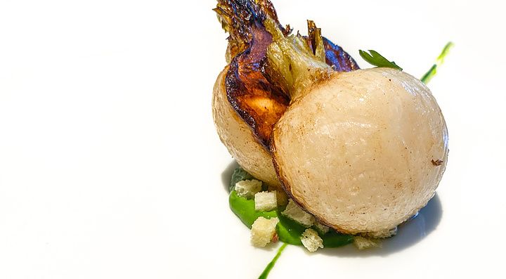 Il piatto iconico di L'Effervescense a Tokyo: una rapa cotta per oltre 4 ore a bassa temperatura su salsa verde.