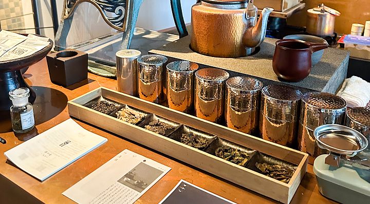 Tavolo con varietà di tè e strumenti di preparazione presso Sakurai Japanese Tea Experience a Tokyo.