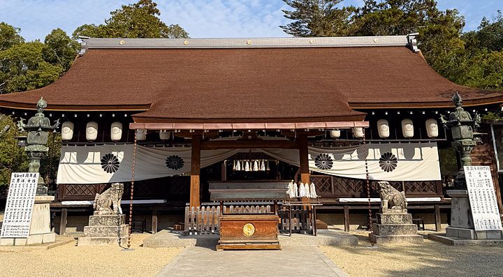 L'edificio principale del Santuario Izanagi sull'isola di Awaji con lanterne in pietra e komainu sotto un cielo sereno.