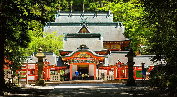 Santuario Kirishima Jingu immerso nel verde con architettura tradizionale in legno rosso e tetti grigi.