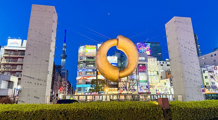 La scultura monumentale a forma di anello dorato si trova nella piazza antistante la stazione di Kinshicho a Tokyo.