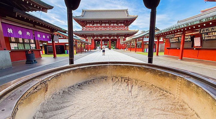 Un bruciatore di incenso circolare in primo piano all'interno del cortile del tempio Senso-ji ad Asakusa, Tokyo.