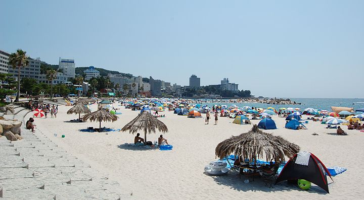 Spiaggia affollata di ombrelloni e persone a Shirahama Beach, Giappone.