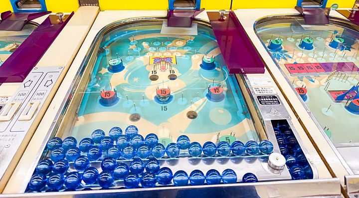 Macchine da gioco vintage in stile flipper con biglie blu presso la sala giochi Smartball New Star a Osaka.