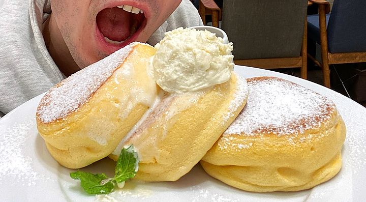 Marco Togni spalanca la bocca davanti a un piatto di pancake soffici nel ristorante a Happy Pancake.