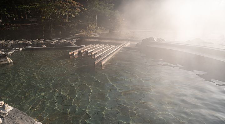Vapore che si leva da una sorgente termale naturale nel parco Sainokawara di Kusatsu Onsen in Giappone.