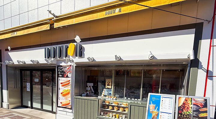 Esterno di un punto vendita Doutor Coffee presso una stazione di servizio in autostrada in Giappone con menu esposti.